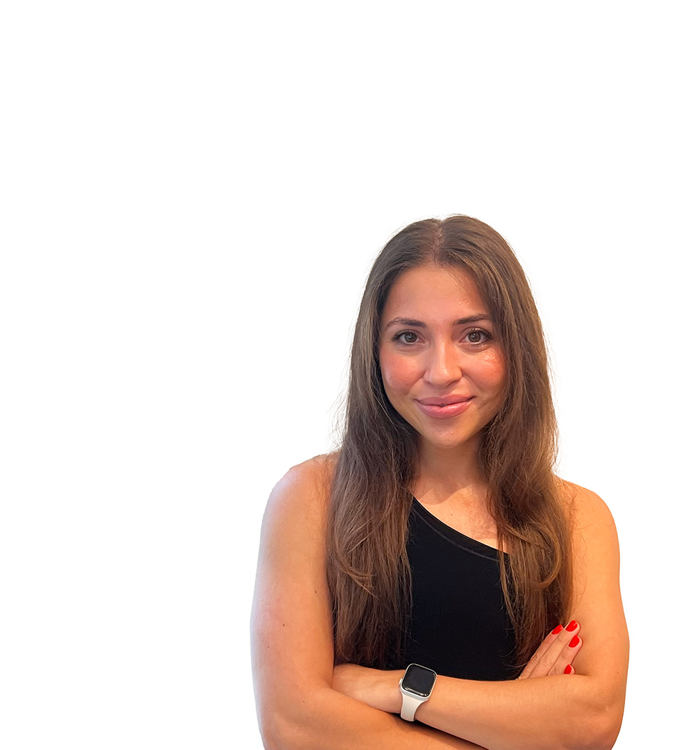 Barry's instructor standing confidently with arms crossed in front, wearing a black tank top against a white background, ready for the next workout challenge.