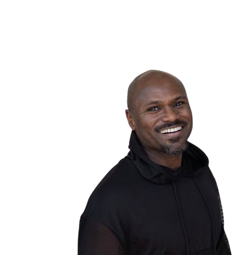 Barry’s instructor wearing a black top standing confidently smiling against a white background