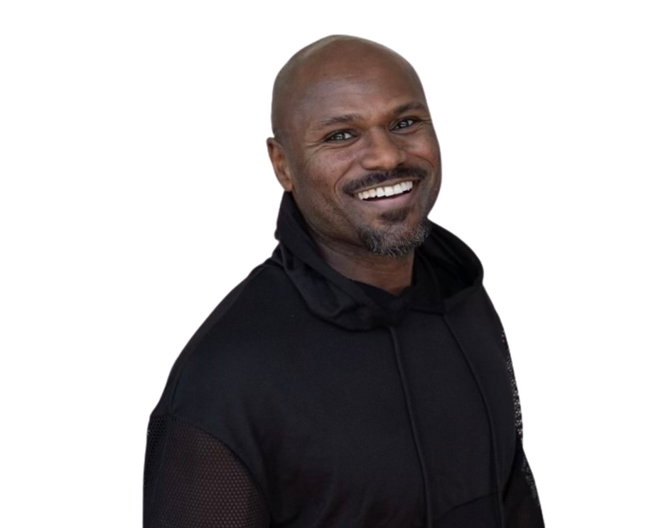 Barry’s instructor wearing a black top standing confidently smiling against a white background