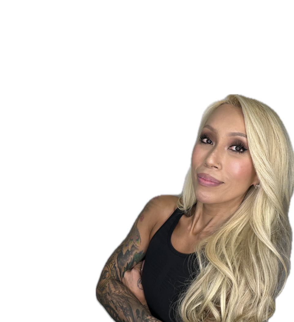 Barry’s instructor wearing a black top standing confidently smiling against a white background