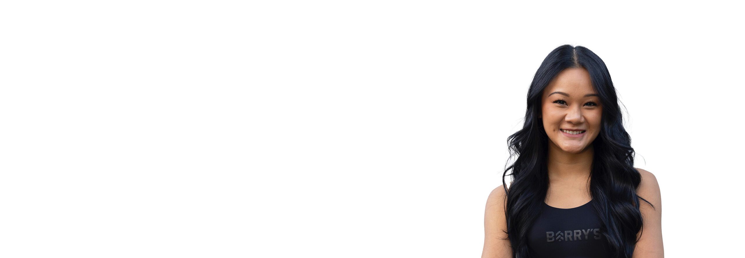 Savannah Le Barry’s instructor wearing a black top standing confidently smiling against a white background