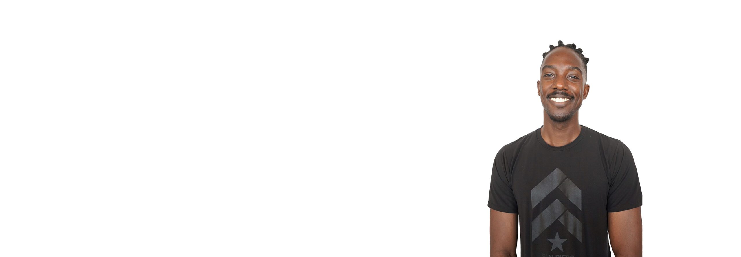 Barry's instructor standing confidently, wearing a black tank top against a white background, ready for the next workout challenge.