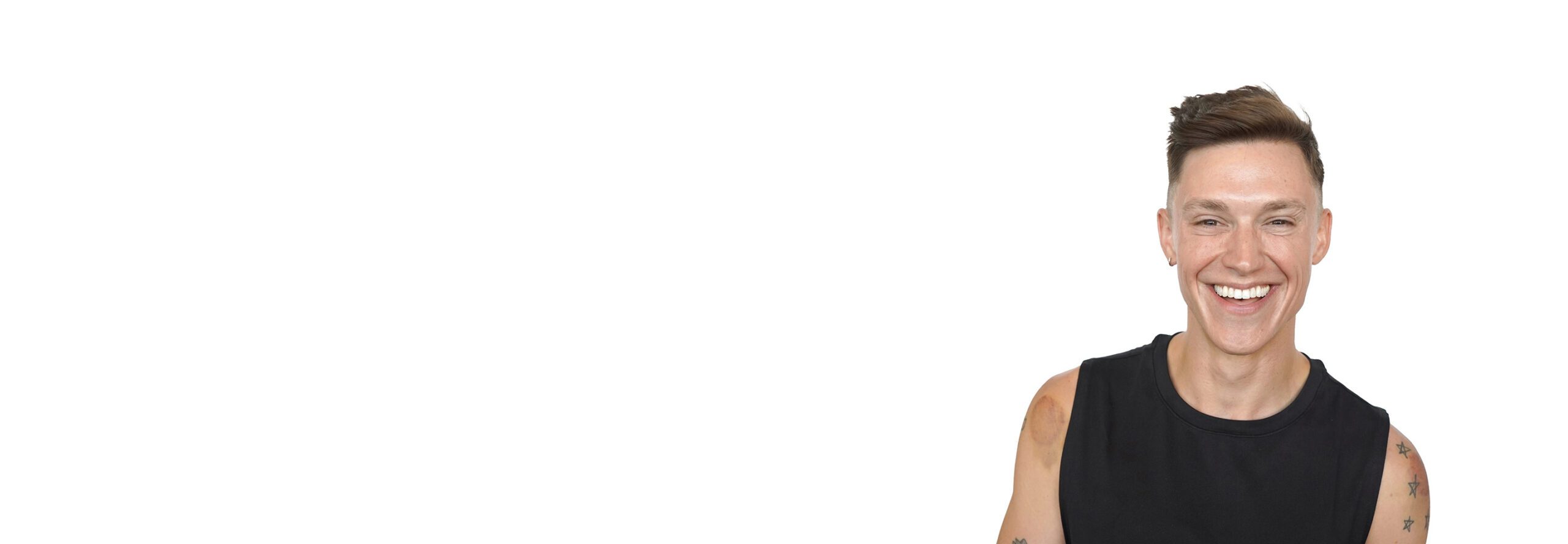 Barry's instructor standing confidently, wearing a black tank top against a white background, ready for the next workout challenge.