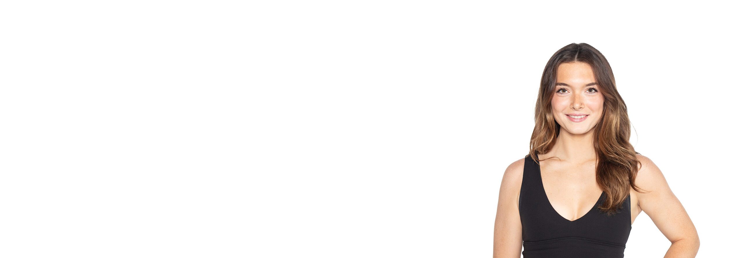 Barry’s instructor wearing a black top standing confidently smiling against a white background