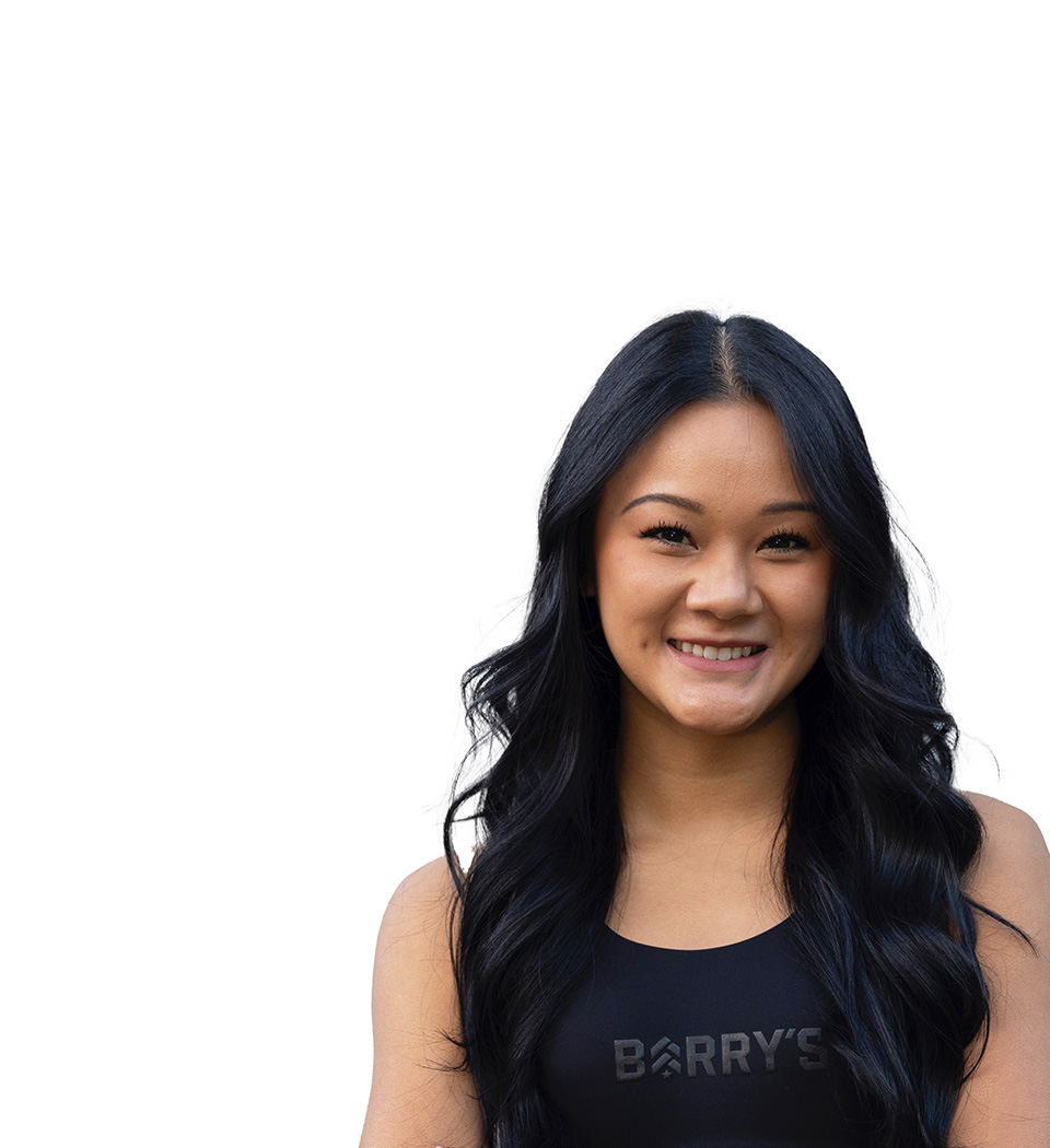 Savannah Le Barry’s instructor wearing a black top standing confidently smiling against a white background