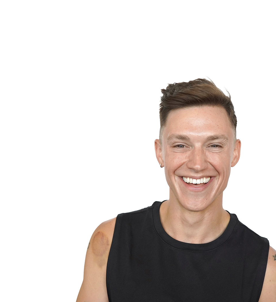 Barry's instructor standing confidently, wearing a black tank top against a white background, ready for the next workout challenge.