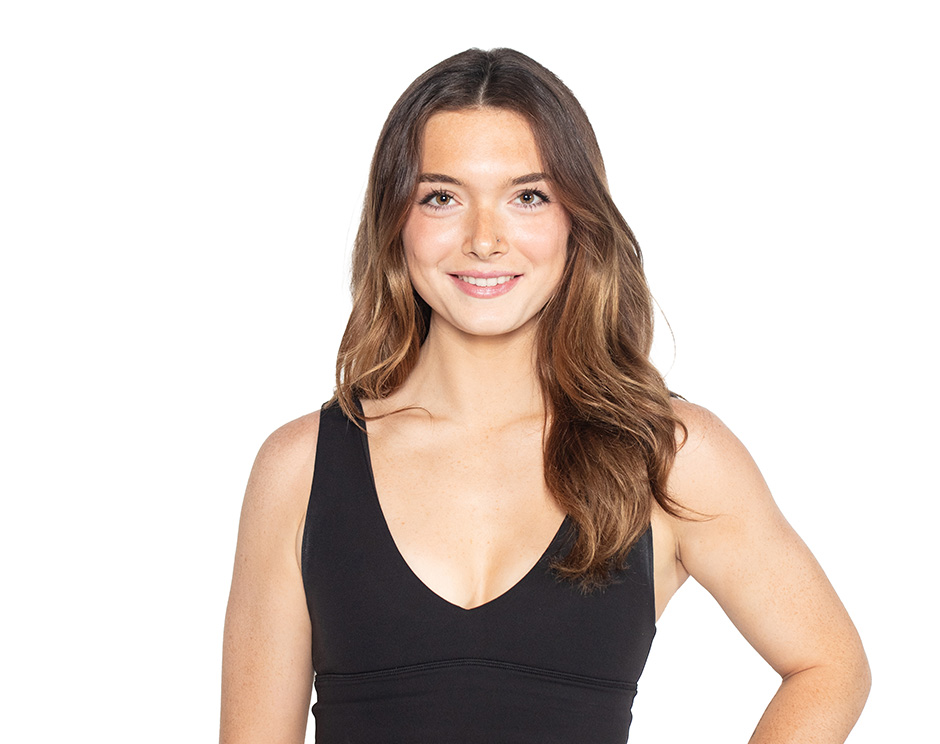 Barry’s instructor wearing a black top standing confidently smiling against a white background