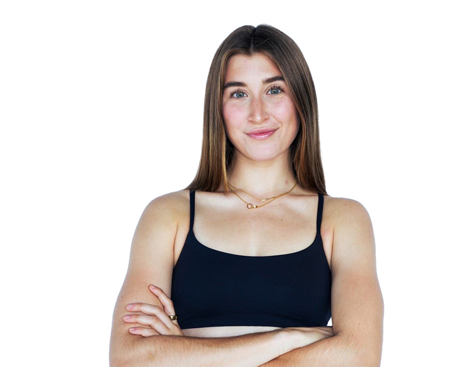 Barry’s instructor wearing a black top standing confidently smiling against a white background