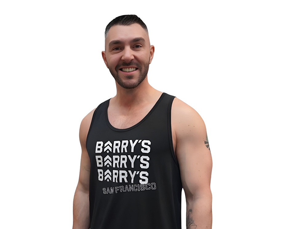 Barry’s instructor wearing a black top standing confidently smiling against a white background
