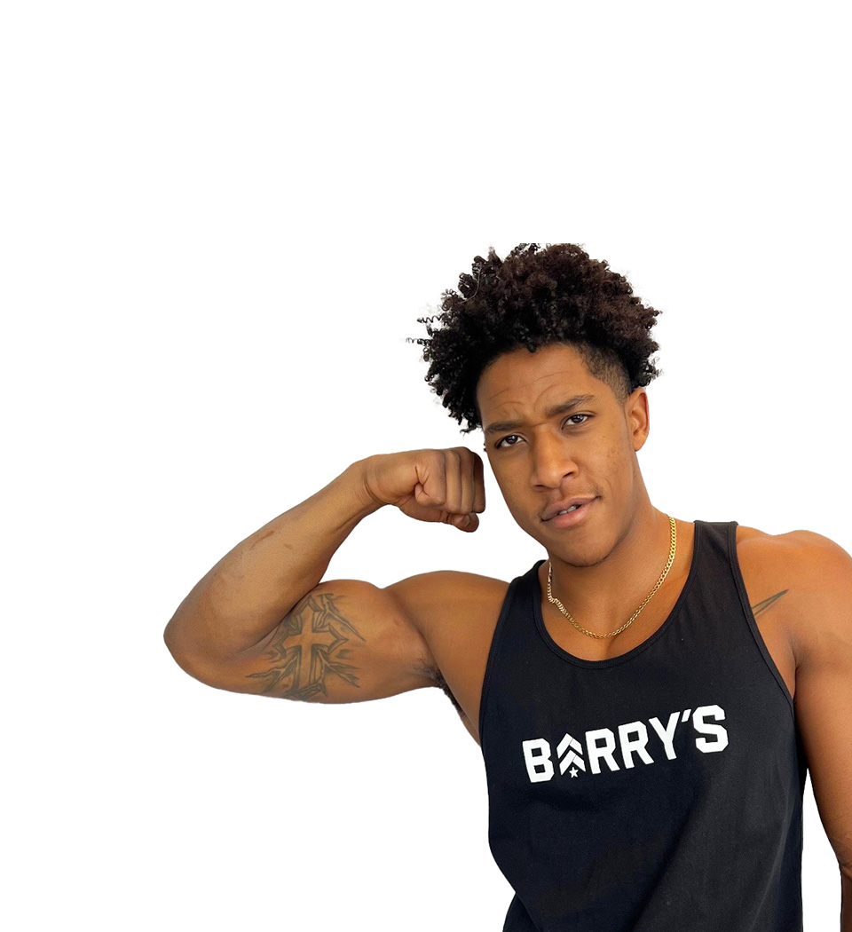 Barry's instructor standing confidently flexing bicep wearing a black top against a white background.