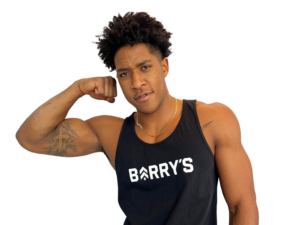 Barry's instructor standing confidently flexing bicep wearing a black top against a white background.