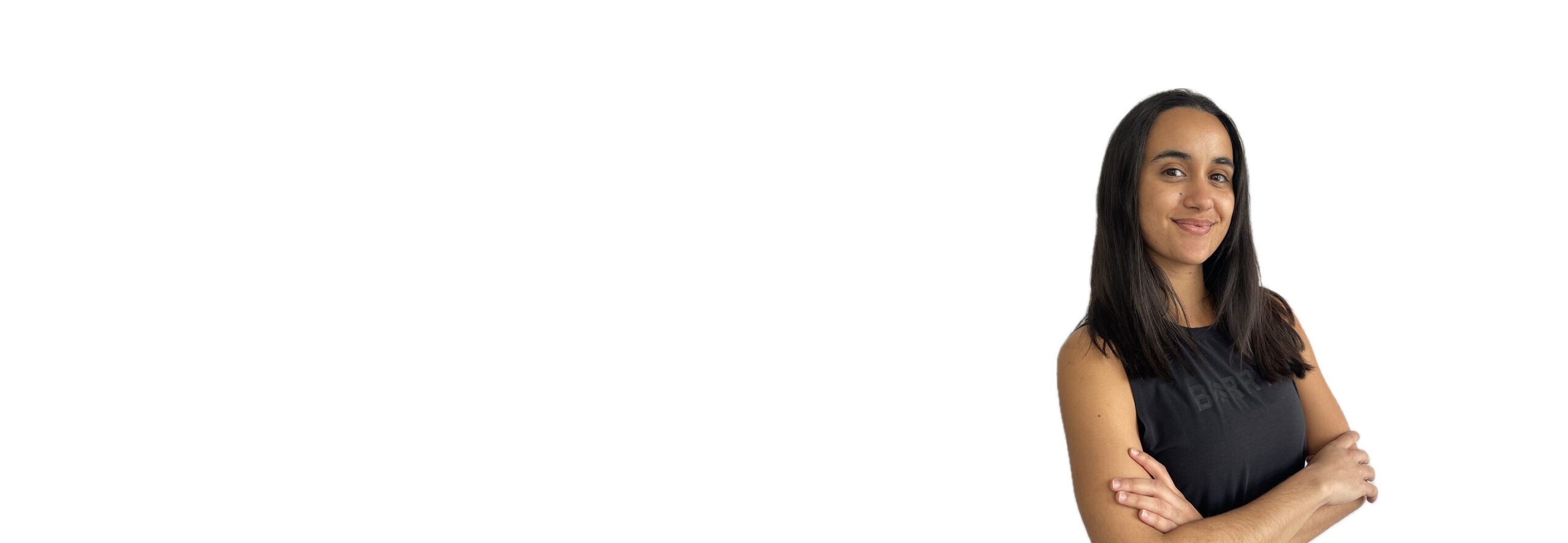 Barry’s instructor wearing a black top standing confidently smiling against a white background