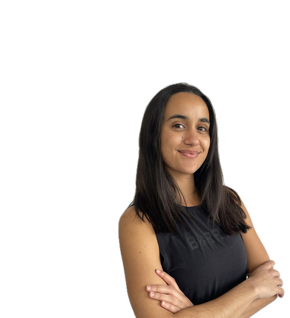 Barry’s instructor wearing a black top standing confidently smiling against a white background