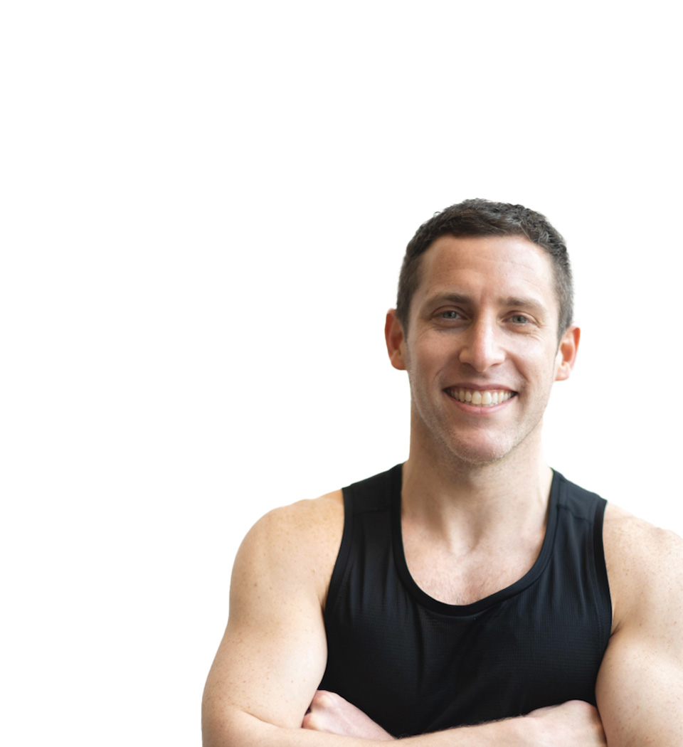 Barry's instructor standing confidently, wearing a black tank top against a white background, ready for the next workout challenge.