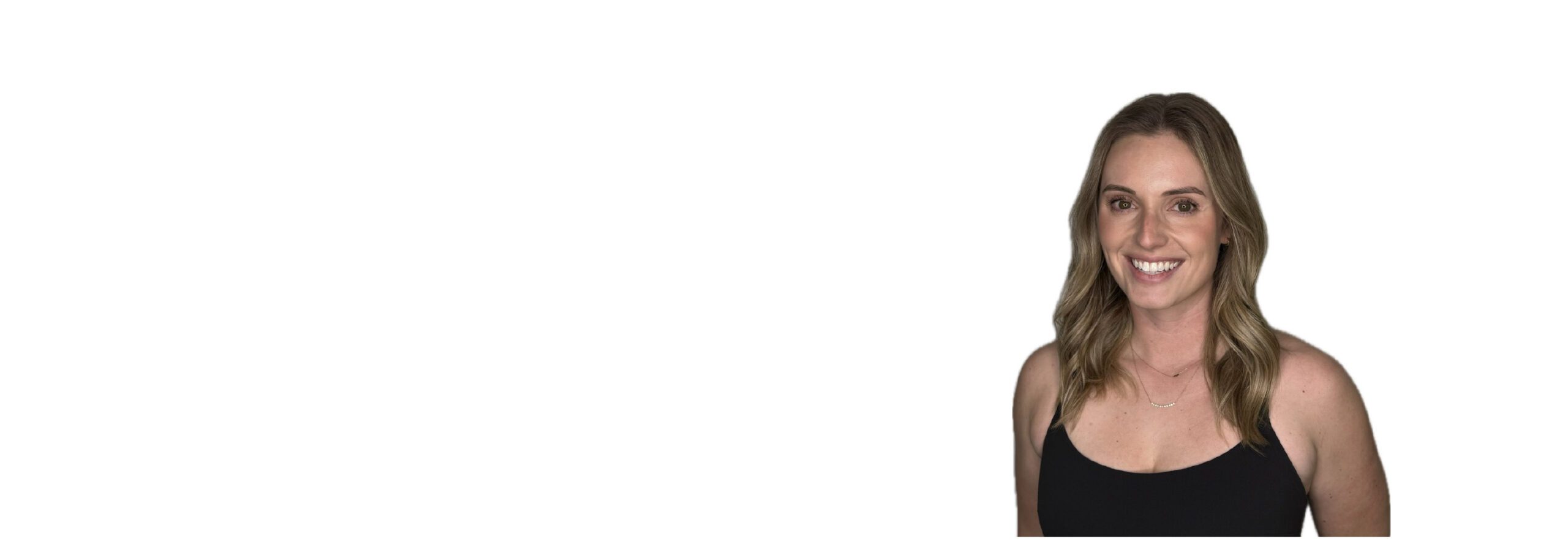 Barry’s instructor wearing a black top standing confidently smiling against a white background