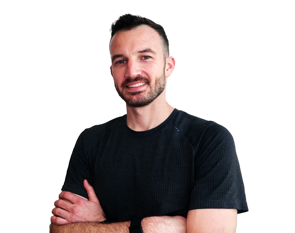 Barry’s instructor wearing a black top standing confidently smiling against a white background