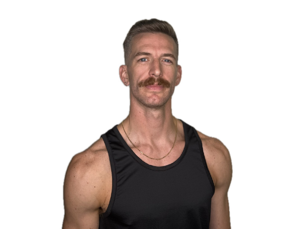 Barry’s instructor wearing a black top standing confidently smiling against a white background