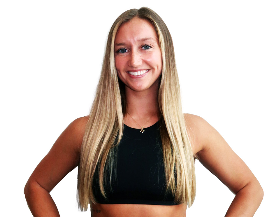 Barry’s instructor wearing a black top standing confidently smiling against a white background