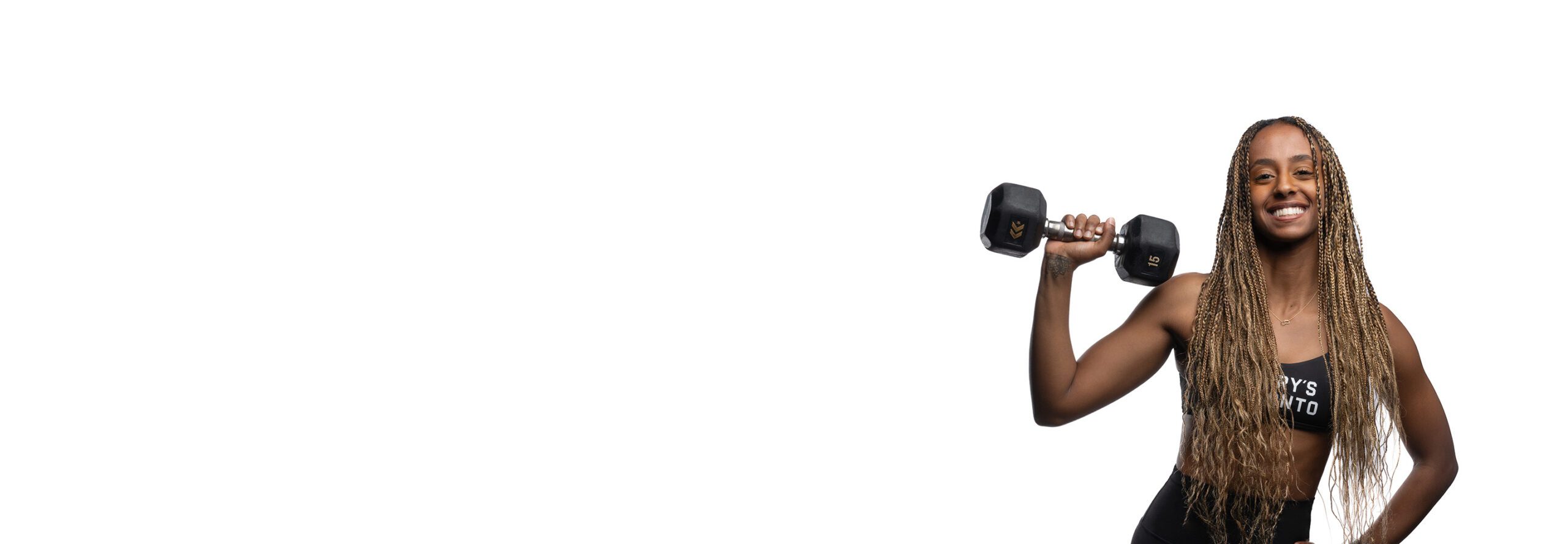 Barry’s instructor wearing a black top standing confidently smiling against a white background