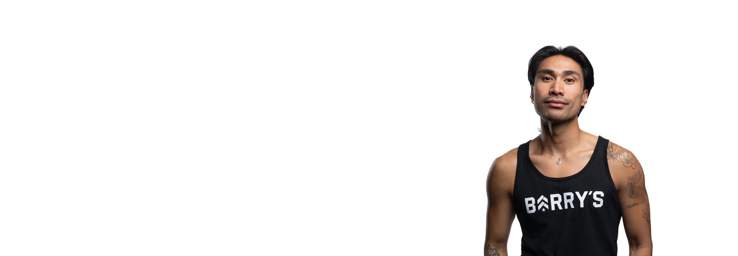 Barry’s instructor wearing a black top standing confidently smiling against a white background