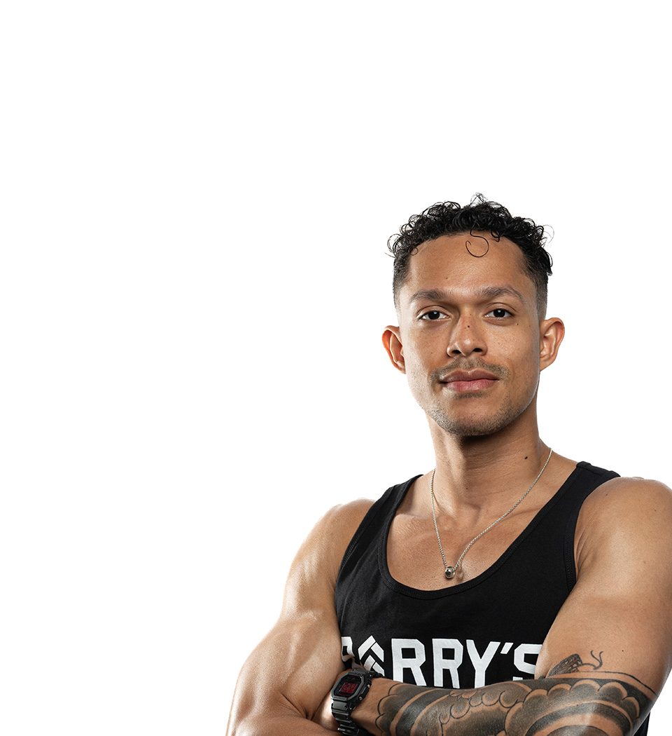 Barry’s instructor wearing a black top standing confidently smiling against a white background