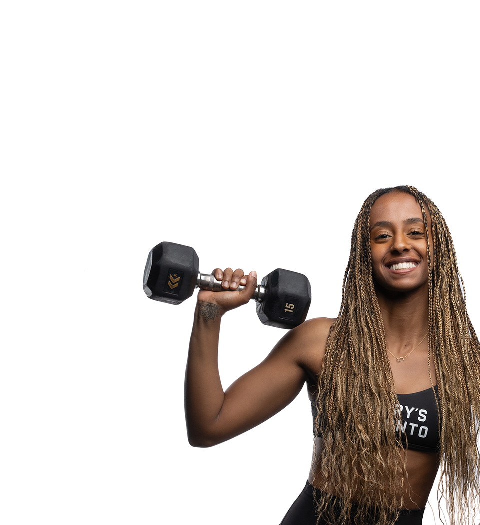 Barry’s instructor wearing a black top standing confidently smiling against a white background